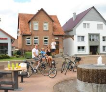 Eine Familie mit Rädern sitzt an einem Brunnen