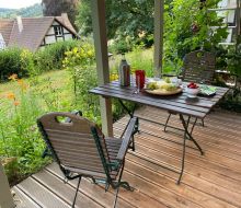 Kleiner Tisch mit zwei Stühlen draußen auf einer Terasse