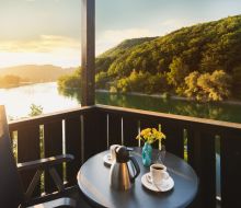 Balkon mit Seeblick, auf dem Tisch steht Kaffee
